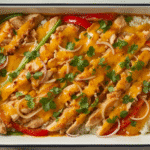 Golden, bubbly chicken fajitas casserole with colorful peppers;