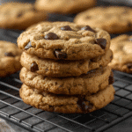 Alt: Golden chocolate chip cookies on parchment with melted chips and sea‑salt flakes