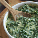Alt: Ingredients for creamed spinach including fresh greens and cream.