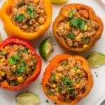 Air fryer basket filled with stuffed bell peppers.