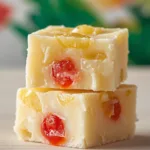 Squares of Pineapple Upside Down Cake Fudge on a wooden board.