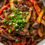 Sizzling Chinese beef and onion stir fry in a wok