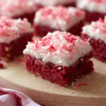 Pink coconut snowball cake bars on a marble surface.