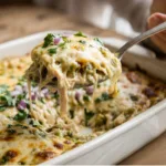 A top-down view of a bubbly Green Chile Chicken Cream Cheese Casserole in a white baking dish.