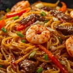 A bowl of Steak and Shrimp Lo Mein served with chopsticks.
