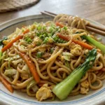 A side-by-side comparison of different noodle types (ramen, udon, egg noodles) with a finished bowl of the fried noodle dish in the background.